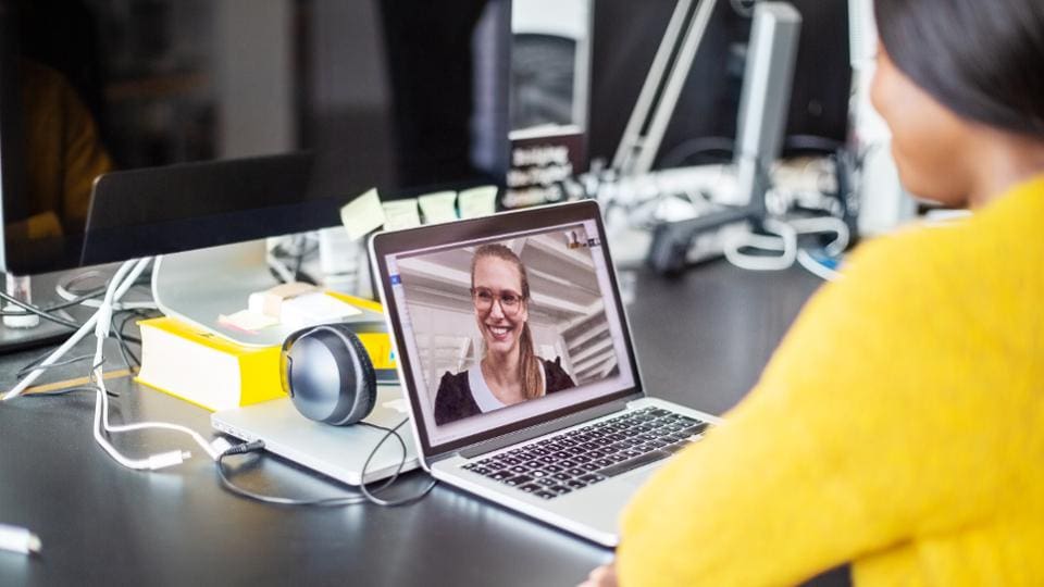 Woman viewing female presenter on laptop screen