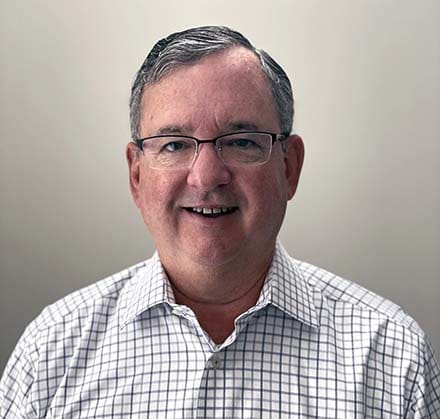 Picture of a white gray haired man with glasses.