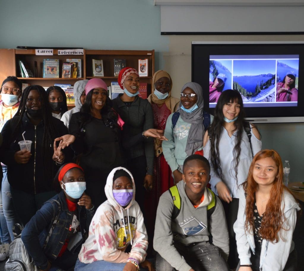 High school students in a classroom with Nursing speaker Shanear Bell in a pink head wrap.