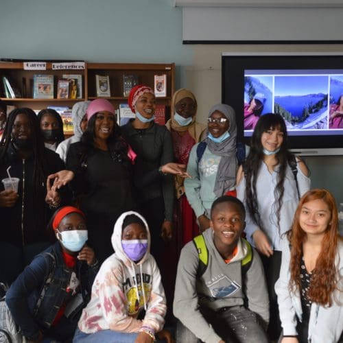 High school students in a classroom with Nursing speaker Shanear Bell in a pink head wrap.