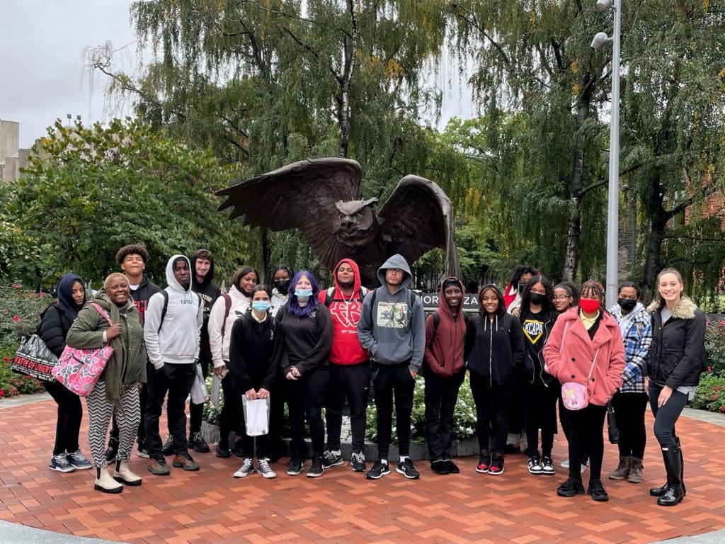 High school students outside at Temple University by a sculpture.