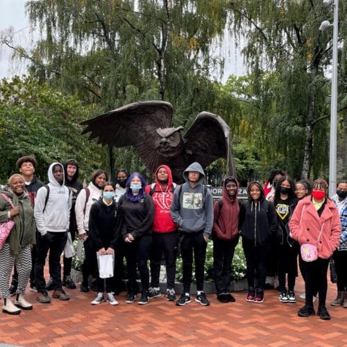 High school students outside at Temple University by a sculpture.